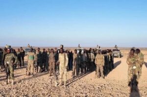 Fighters of the Calmiskaad Defence Forces drawn up with technicals on open ground in Puntland after leaving Carmo for Xumbays