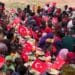 Children at a Merhem food distribution in Somalia eating at long rows of plates lined with small Turkish flags
