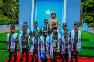 Children of fallen Somali National Army soldiers in uniform and Agoonta Ciidanka sashes with an army officer, the families the Orphans Care Agency was founded to support
