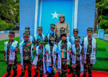 Children of fallen Somali National Army soldiers in uniform and Agoonta Ciidanka sashes with an army officer, the families the Orphans Care Agency was founded to support