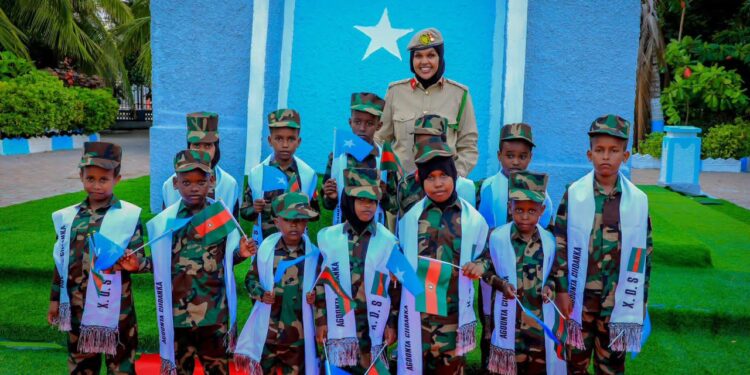 Children of fallen Somali National Army soldiers in uniform and Agoonta Ciidanka sashes with an army officer, the families the Orphans Care Agency was founded to support