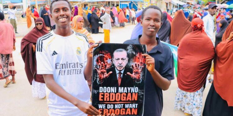 Protesters in Kismayo holding a poster of President Erdogan with bloodied hands during the anti-Turkiye demonstration