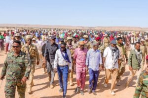 President Said Abdullahi Deni walking with residents and escorts at Gunbax in Raas Caseyr during his tour of Puntland far eastern districts