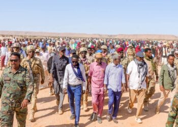 President Said Abdullahi Deni walking with residents and escorts at Gunbax in Raas Caseyr during his tour of Puntland far eastern districts