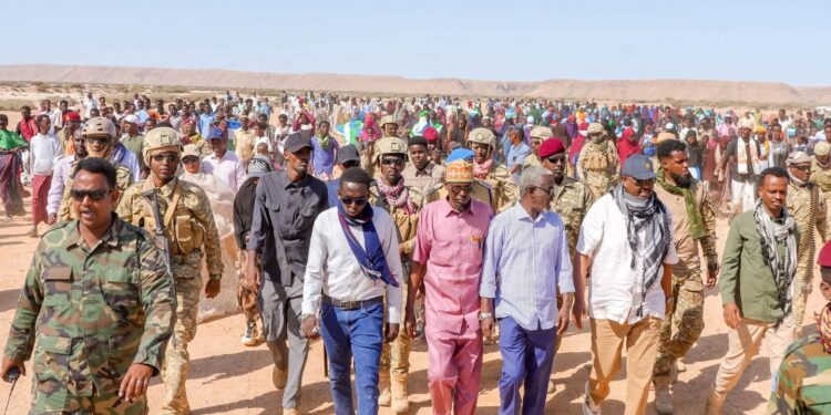 President Said Abdullahi Deni walking with residents and escorts at Gunbax in Raas Caseyr during his tour of Puntland far eastern districts