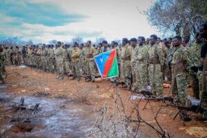 Fighters loyal to Abdiaziz Laftagareen with belt-fed machine guns and the South West State flag in open country on the outskirts of Baidoa