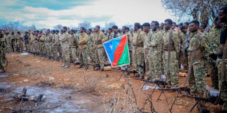 Fighters loyal to Abdiaziz Laftagareen with belt-fed machine guns and the South West State flag in open country on the outskirts of Baidoa