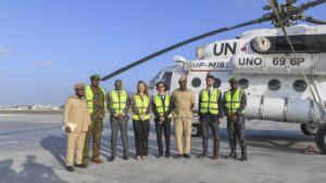 UNSOS, Somali and African Union personnel beside a United Nations helicopter at Mogadishu airport