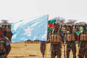 Newly graduated Somali National Army soldiers carry the Somali flag on the parade ground at Xananbuure in Galgadud, the class from which hundreds later crossed into Ethiopia's Somali Region
