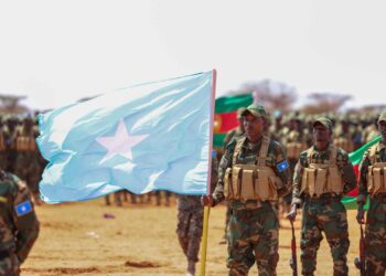 Newly graduated Somali National Army soldiers carry the Somali flag on the parade ground at Xananbuure in Galgadud, the class from which hundreds later crossed into Ethiopia's Somali Region