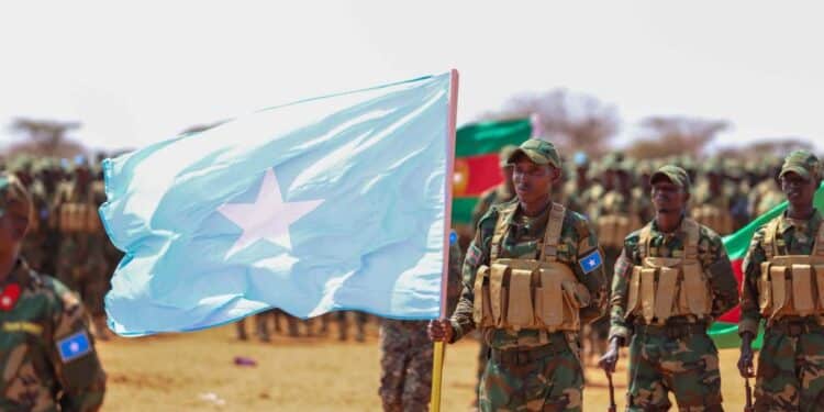 Newly graduated Somali National Army soldiers carry the Somali flag on the parade ground at Xananbuure in Galgadud, the class from which hundreds later crossed into Ethiopia's Somali Region
