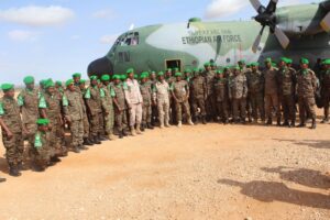 ENDF soldiers serving with AUSSOM in Somalia beside an Ethiopian Air Force transport aircraft during a troop rotation