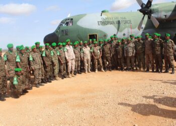 ENDF soldiers serving with AUSSOM in Somalia beside an Ethiopian Air Force transport aircraft during a troop rotation