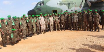 ENDF soldiers serving with AUSSOM in Somalia beside an Ethiopian Air Force transport aircraft during a troop rotation