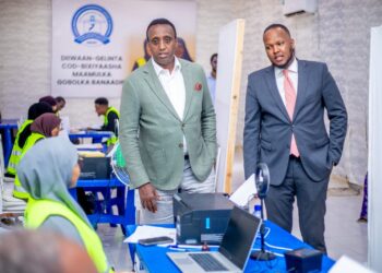 Officials visit a Banadir voter registration centre in Mogadishu run by Abdikarim Ahmed Hassan's electoral commission, with staff in high-visibility vests at the desks